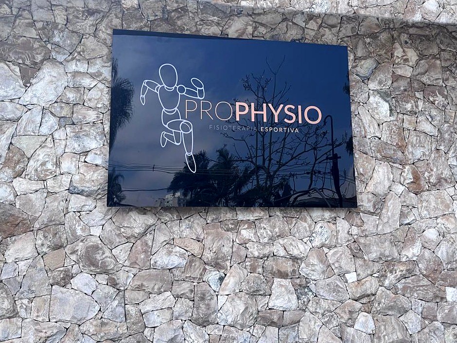 Placa de acrílico com impressão UV da Prophysio em parede de pedra
